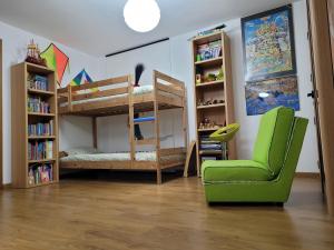 法鲁彩色一室公寓的客房设有两张双层床和一张绿色椅子。