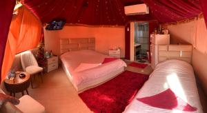 卡拉克Bubble castle house的一间卧室设有两张床和红色天花板