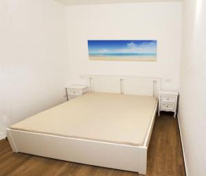 圣特雷莎加卢拉Grazioso bilocale a Santa Teresa di Gallura的卧室内的白色床,设有白色的墙壁