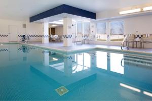 韦恩堡韦恩堡北汉普顿酒店及套房的大楼内一个蓝色瓷砖的大型游泳池