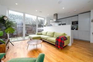 伦敦GuestReady - Modern lodge with garden的客厅配有沙发和桌子