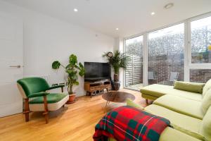 伦敦GuestReady - Modern lodge with garden的带沙发和电视的客厅