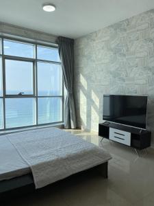 阿吉曼Ocean View Luxury Suites的一间卧室配有一张床和一台平面电视