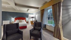 唐克斯特欧斯敦霍尔酒店的酒店客房,配有一张床和两把椅子