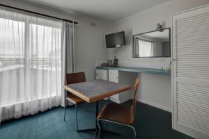 仙女港仙女港中央汽车旅馆的酒店客房设有一张桌子和一面镜子