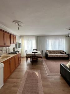 艾瓦勒克亚德公寓旅馆的厨房以及带桌子和床的客厅。