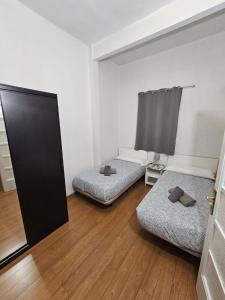 瓦伦西亚图里亚公寓的两张位于一间可打开门的房间内的床