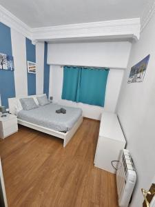 瓦伦西亚图里亚公寓的一间卧室设有床铺和蓝色及白色的墙壁