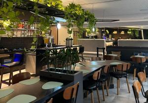 累西腓Fity Hotel的一间设有桌椅的餐厅,种植了植物