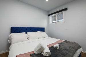 蒙特朗布朗The Nordic 2BR Chalet by Instant Suites - 5 min to Tremblant Village的一间卧室配有一张带蓝色床头板的床和窗户