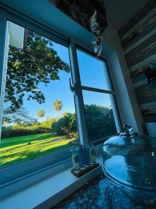 BombitaPERLA MARINA BEACH的带水槽的浴室窗户,享有田野美景