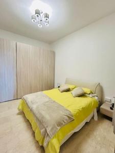 斯利马XL Seafront Home in Sliema的一间卧室配有一张黄色毯子床