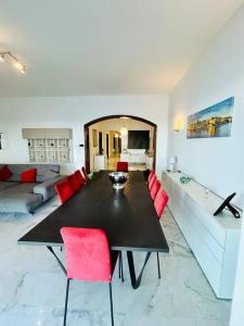 斯利马XL Seafront Home in Sliema的一间用餐室,配有黑桌子和红色椅子