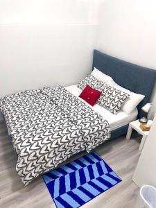 多伦多Scarborough New 2-Bedroom Basement的一张配有黑白床单和红色枕头的床