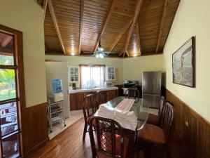 特拉Honduras Shores Plantations的厨房设有玻璃桌和木制天花板。