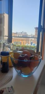 兰佩杜萨RgB_Apartments的坐在窗边桌子上的一碗水果