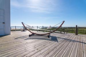 欧瓦Tijosa Eco-House Camp的海滩甲板上的木凳