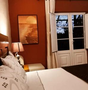 蒙萨拉什圣卡塔里娜山旅馆的一间卧室配有一张床,一扇门设有窗户