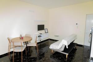 普拉亚Cidadela Apartamento的客房设有桌子、床和桌椅。