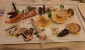 威尼斯Hotel Ristorante Ca' Nova的桌上一盘带海鲜的食品