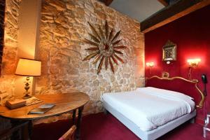 巴黎埃斯梅拉达酒店的卧室配有一张床和一张桌子,墙上挂着一个时钟