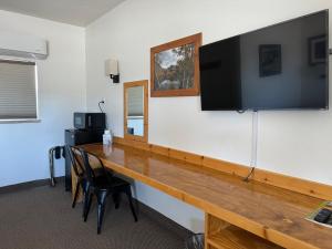 独立城Eastern Sierra Motor Lodge的一张桌子,墙上挂着大电视