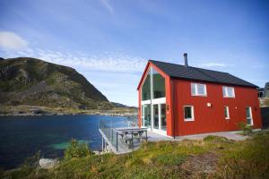 巴尔斯塔Cabin in Lofoten with spectacular view的水体上的一个红色房子