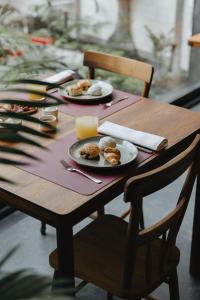 蓬塔德尔加达NINE DOTS Azorean Art Boutique Hotel的一张木桌,上面放着盘子和一杯橙汁