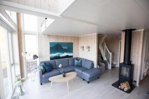 巴尔斯塔Cabin in Lofoten with spectacular view的客厅设有蓝色的沙发和壁炉