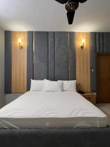 卡拉奇Marigold Accommodations的一间卧室配有一张带白色床单的大床