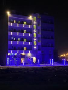 卡拉奇Marigold Accommodations的一座建筑,前方有蓝色的灯光,晚上