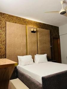 卡拉奇Marigold Accommodations的客房内的一张带白色枕头的床