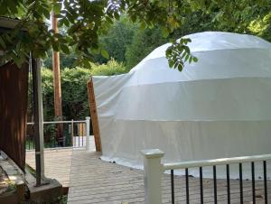 SuttonGlampOut Resort - Elk River的树下甲板上的白色帐篷