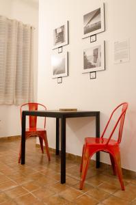 塔兰托Downtown Lodge Museum的一张桌子、两把椅子和墙上的照片