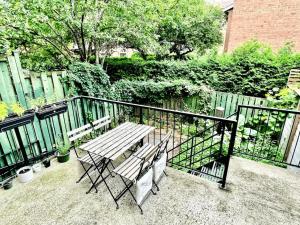 蒙特利尔Beautiful Luxury Shared Home in Montreal的一个带围栏的阳台,配有一张木桌子和椅子