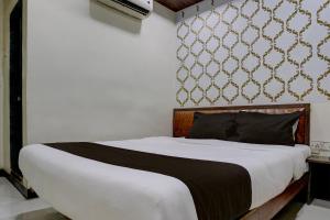 孟买Mumbai Residency的一间卧室配有一张带白色床单和墙壁的大床