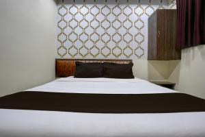 孟买Mumbai Residency的卧室配有一张带黑色枕头的白色床