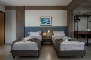 乌贝兰迪亚Lym Flat Hotel的客房设有两张床和一张带台灯的桌子。