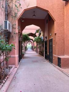 马拉喀什Riad Paolo Piscine Palmeraie的大楼里一条有拱门的空巷