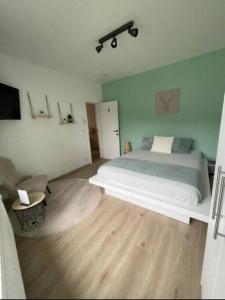 普罗丰德维耶Maison entièrement privative的卧室设有一张白色大床和木地板