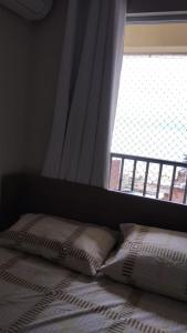 福塔莱萨Villa damasco的窗户前的一张带两个枕头的床