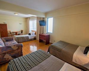 圣地亚哥HOTEL DACARLO的酒店客房设有两张床和一张桌子。