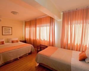 圣地亚哥HOTEL DACARLO的酒店客房设有两张床和窗户。