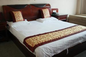 台州台山商务宾馆的一间卧室配有一张大床和木制床头板