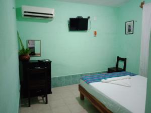 VeneciaHospedaje Wotoch Aayin的卧室配有一张床,墙上配有电视。