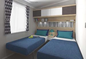 InversnaidLoch Lomond Holiday Park的一间卧室设有两张带蓝色床单的床和窗户。