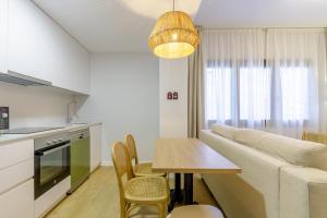 马拉加Malagueta Miramar with Shared Pool by Caleta Homes的厨房以及带沙发和桌子的客厅。