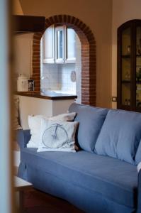 GelloAntico Podere Sant'Anna的蓝色的沙发,上面有枕头,上面有自行车