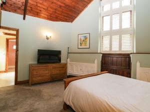 卡林顿Frogwell Chapel的一间卧室配有一张床和一台平面电视