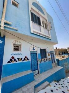 阿斯旺Bakar House的蓝色和白色的建筑,设有蓝色的门